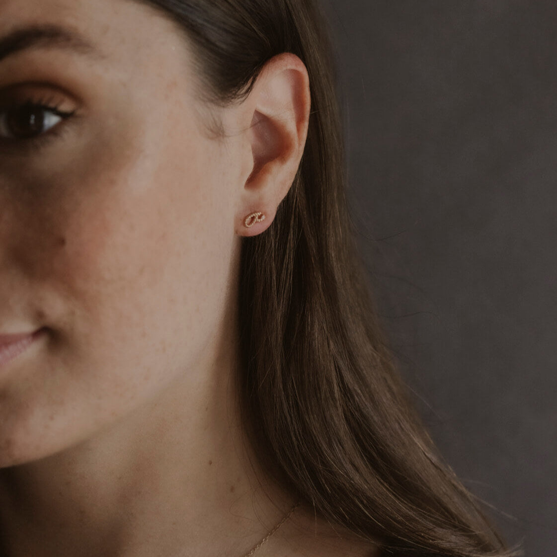 Model wears Fuck Gold Shorthand Stud Earrings