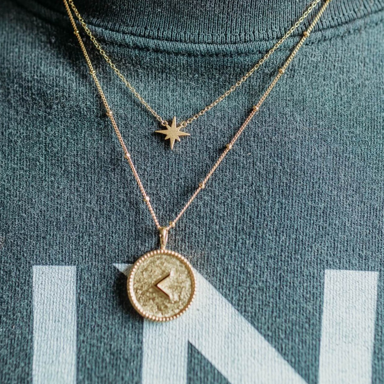 model-wears-14k-gold-vermeil-kind-shorthand-coin-disc-necklace-and-gold-vermeil-brushed-star-dainty-necklace-claire-hill-designs-close-up