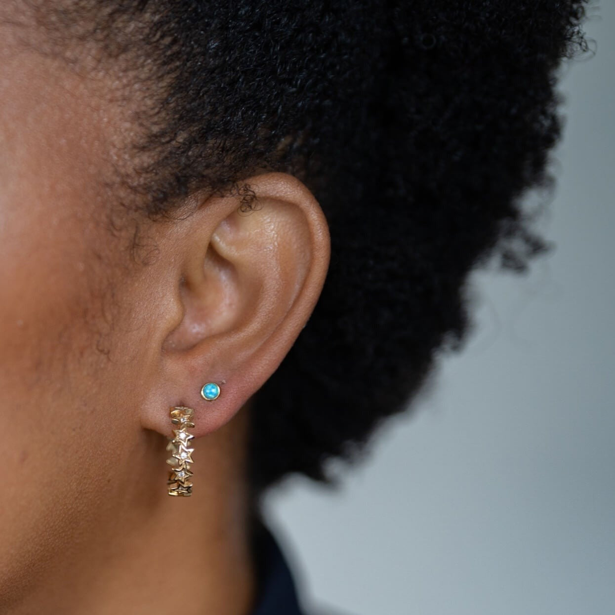 model wears sparkly gold vermeil star hoop earrings and 18k gold vermeil and blue lab-grown opal stud earrings