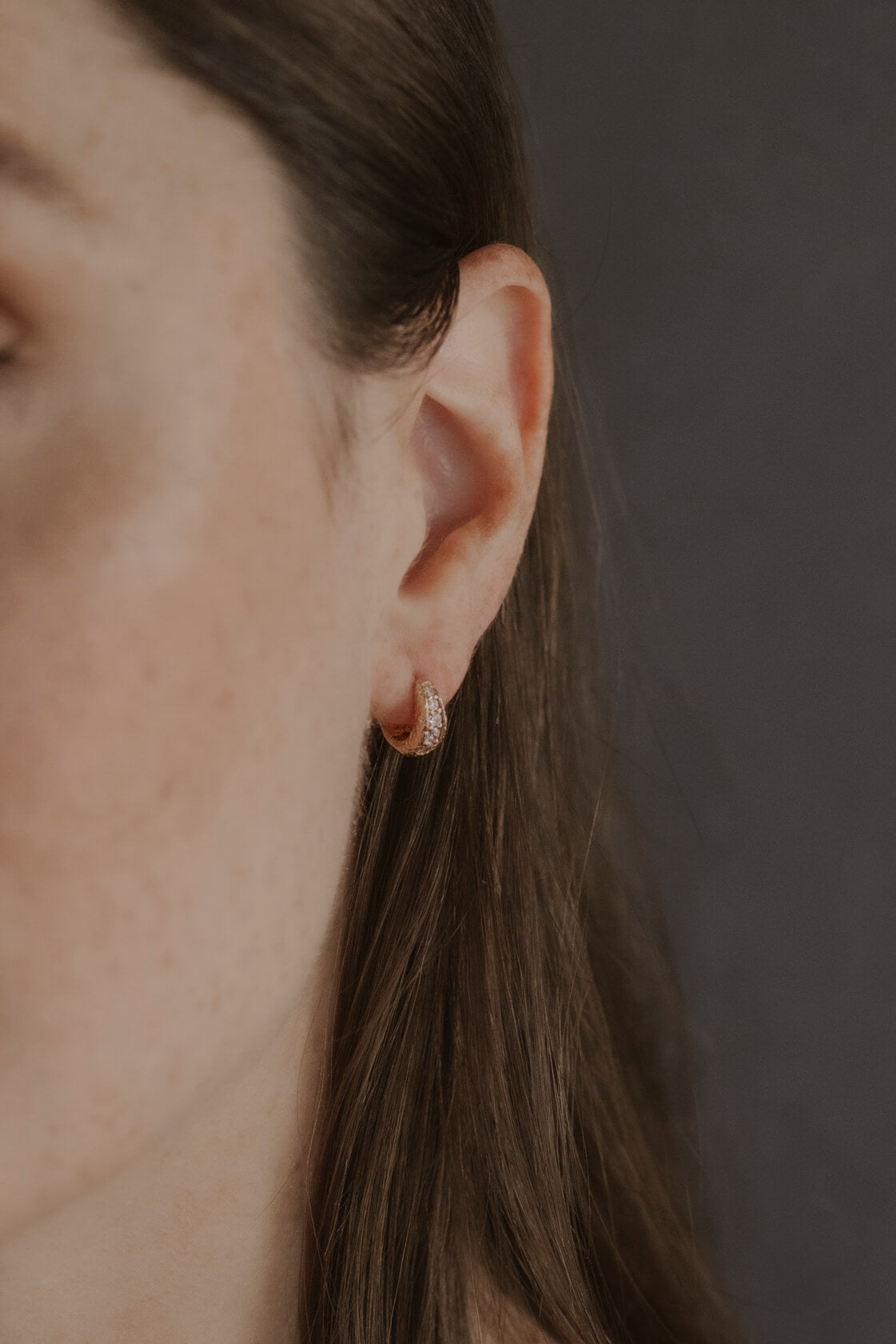 model wears Lab-grown diamond antique gold huggie hoops