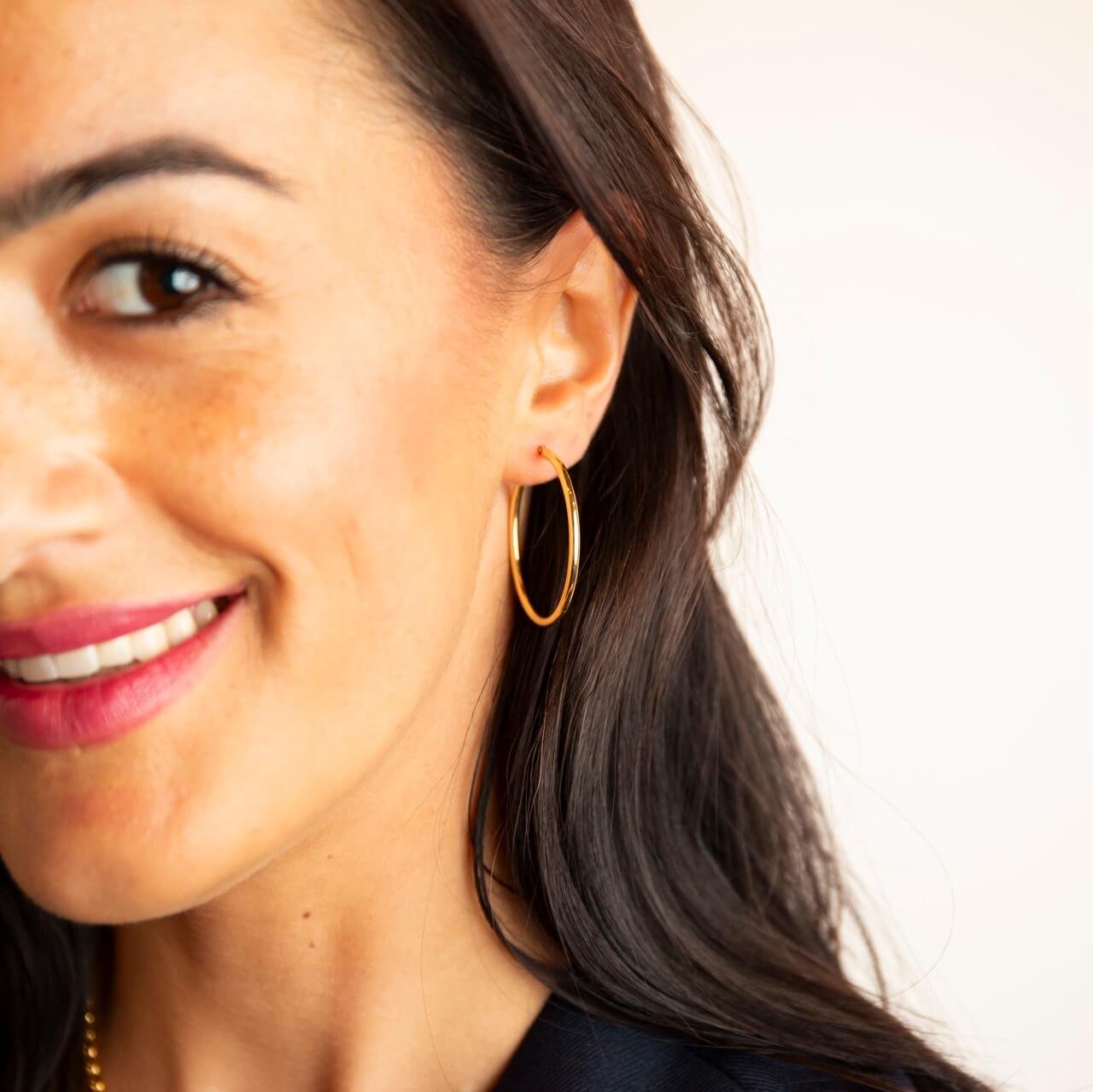 model wears 9ct solid gold oval 24mm hoop earrings