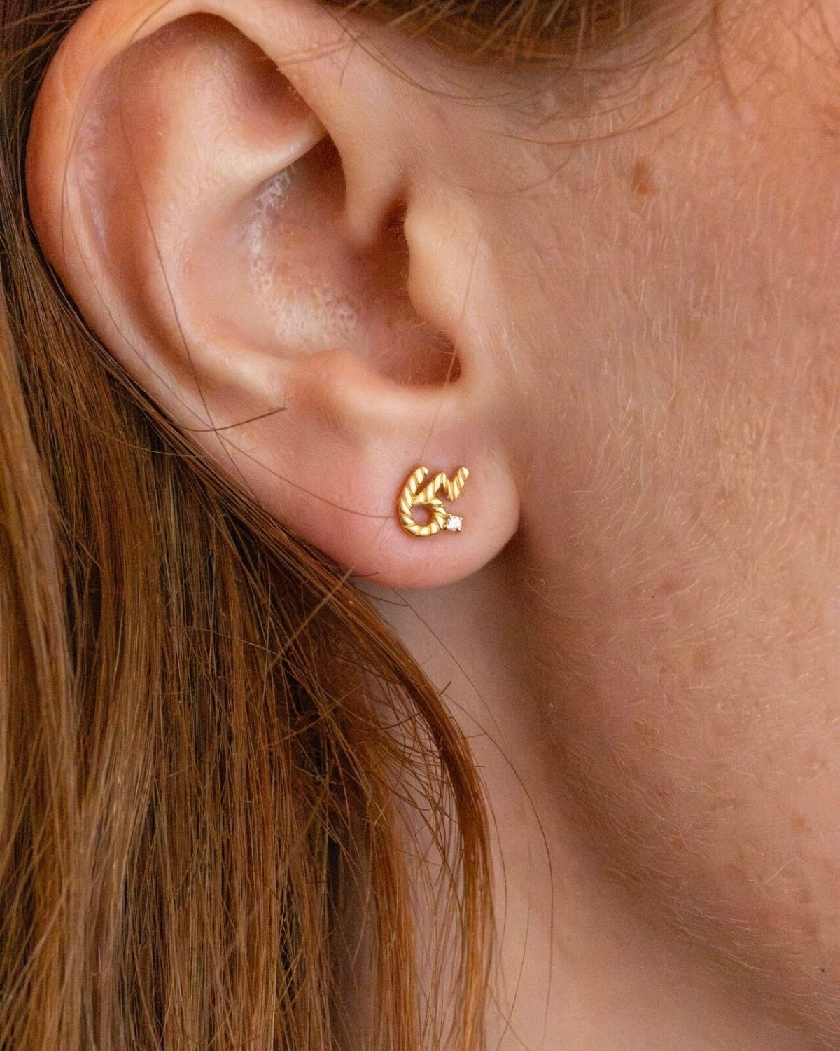 model wears Brave Gold Shorthand Stud Earring