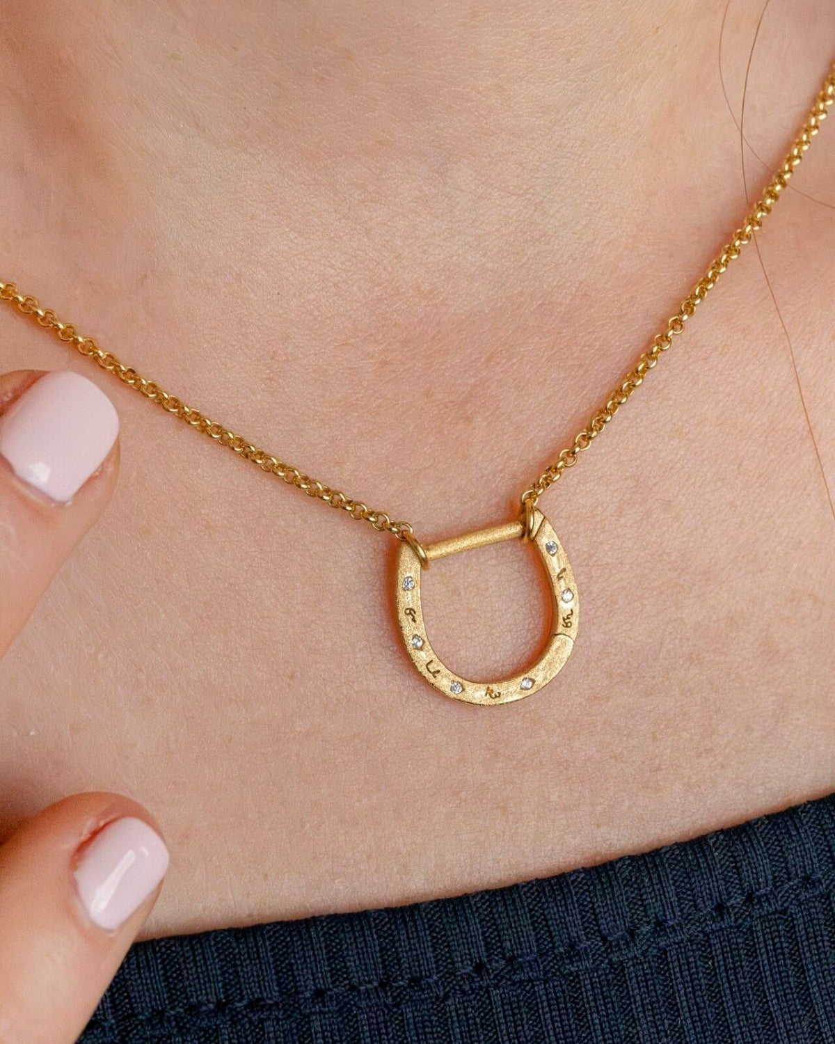 model wears shorthand gold horseshoe charm connector necklace