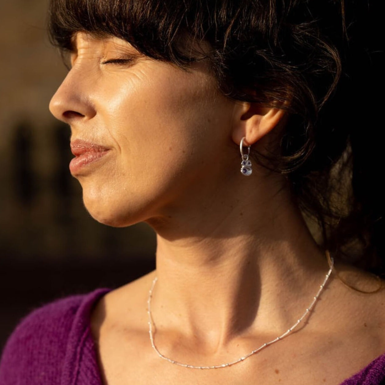 model-wears-silver-amethyst-birthstone-hoop-earring-and-silver-satellite-beaded-chain-necklace-claire-hill-designs