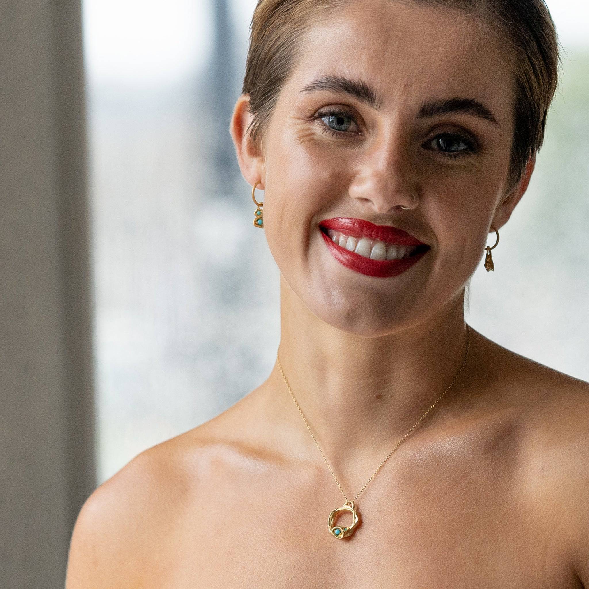 model wears Turquoise and Gold Lichen Hoop Earrings and matching turquoise necklace
