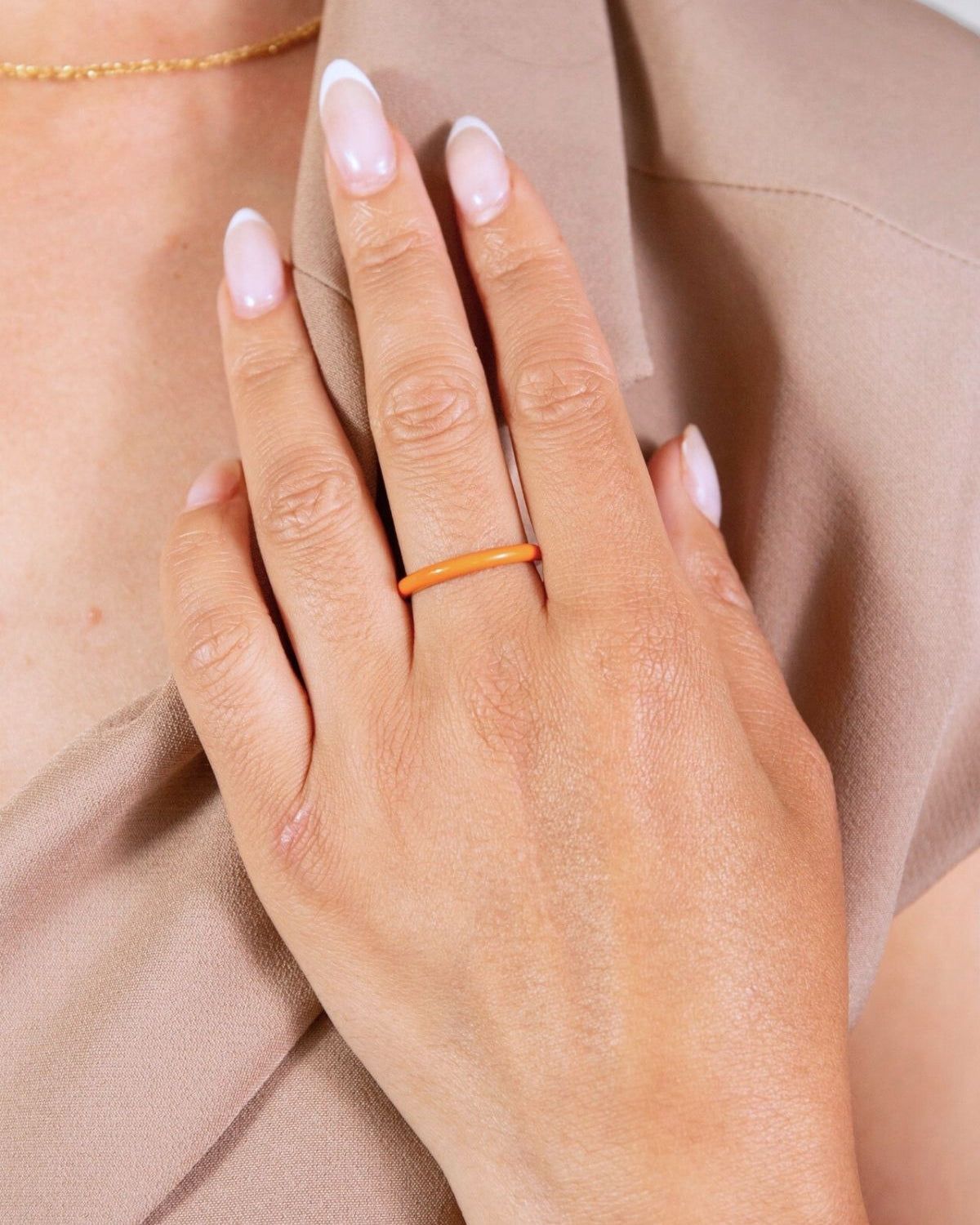 model wears coral enamel ring