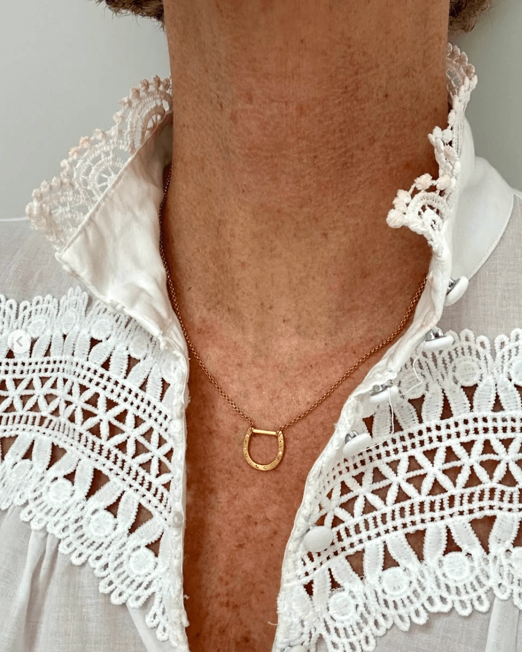 Stripey Coral wears horseshoe shorthand necklace