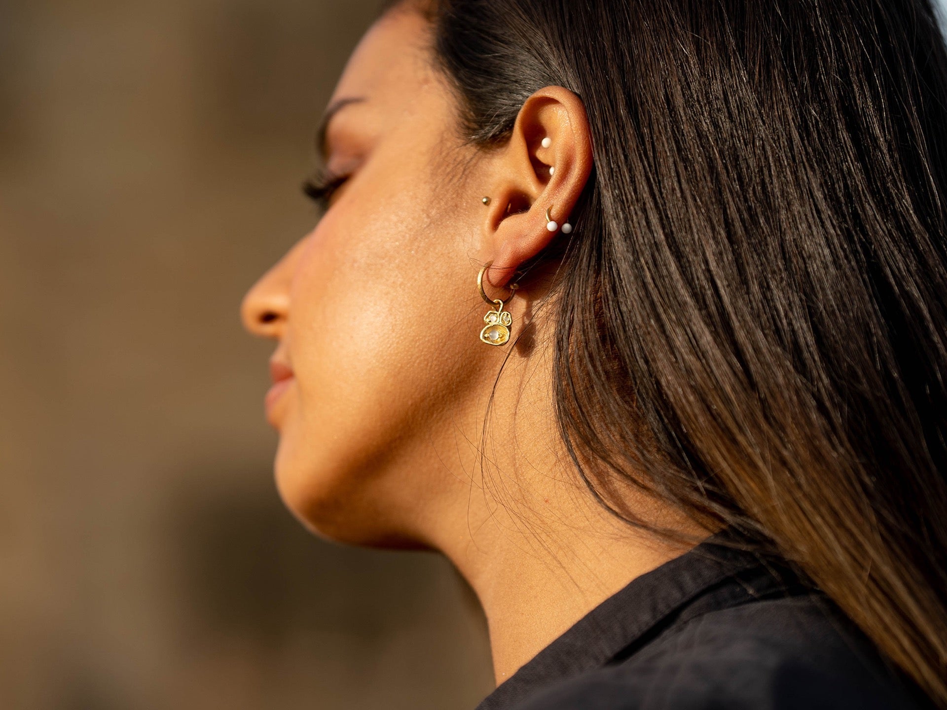 Model wears moonstone gold hoop earrings