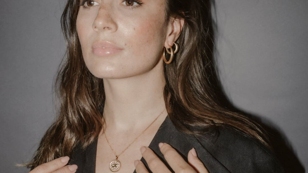 Model wears large gold hoops