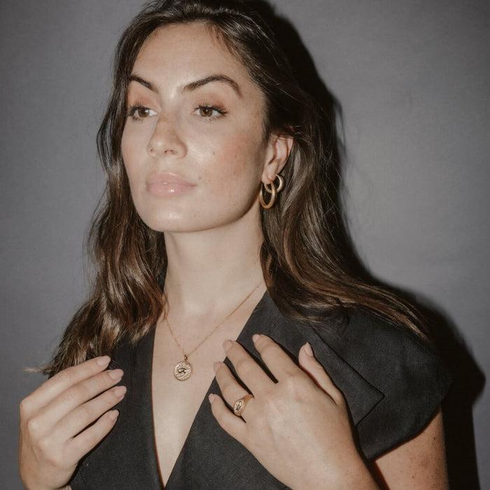 Model wears large gold hoops