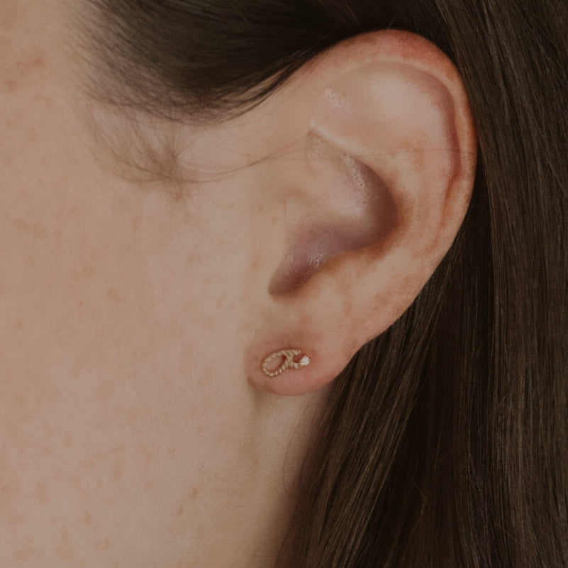 Model wears gold vermeil Fuck Shorthand Stud Earring