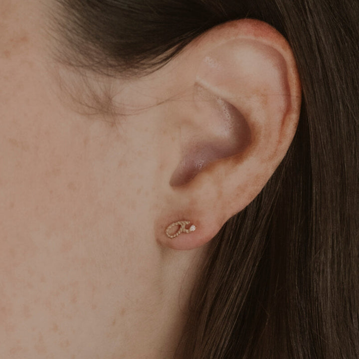 Model wears gold vermeil Fuck Shorthand Stud Earring