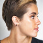 model wears 18k gold vermeil and black cubic zirconia scatter huggie hoops and brushed 18k gold vermeil north star stud earring