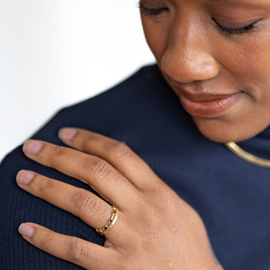model wears 18k gold vermeil and black cubic zirconia studded dainty stacking ring and 18k gold vermeil antique textured stacking ring 