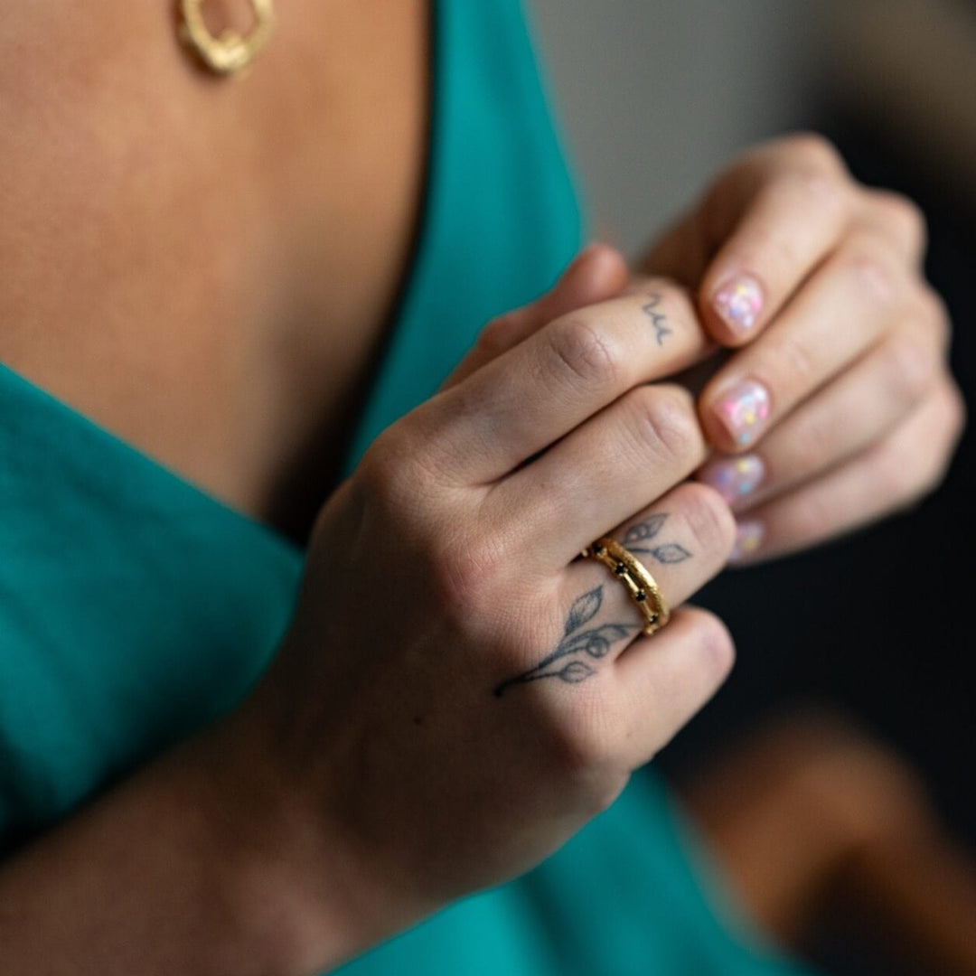 model wears 18k gold vermeil and black cubic zirconia studded dainty stacking ring and 18k gold vermeil antique textured stacking ring