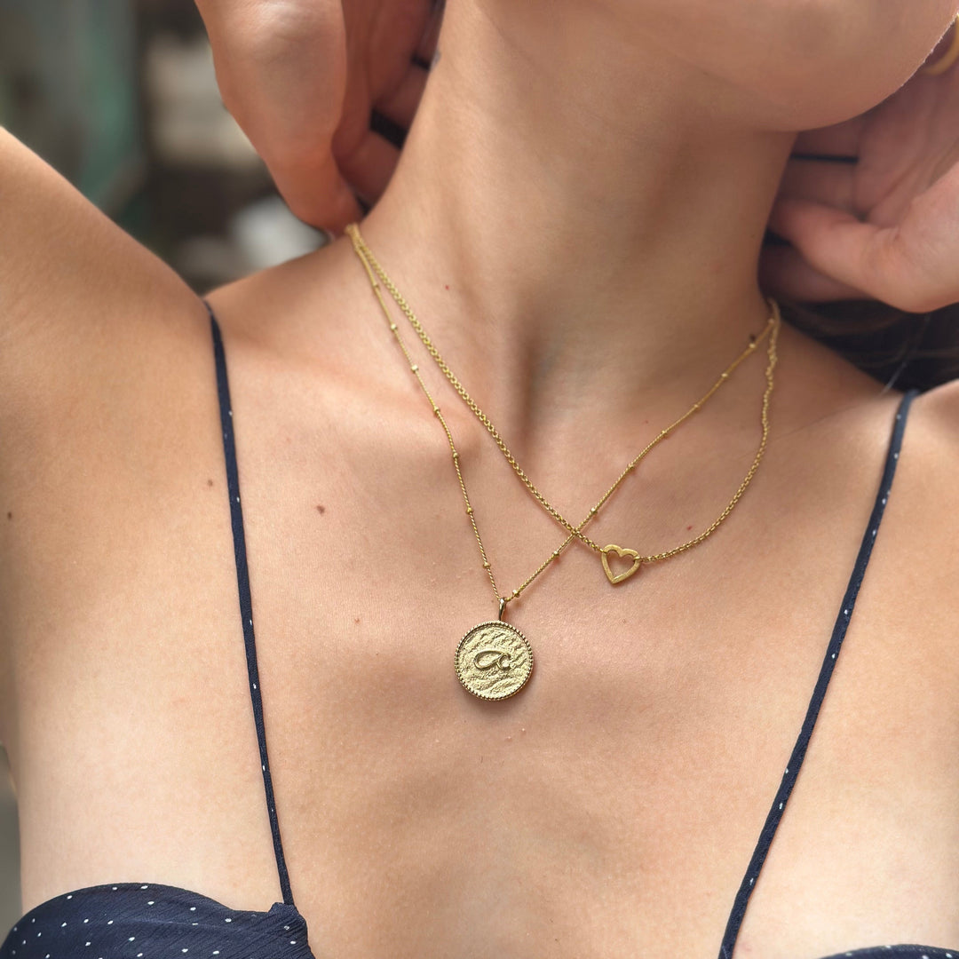 model wears “Fuck” Gold Shorthand Coin Necklace