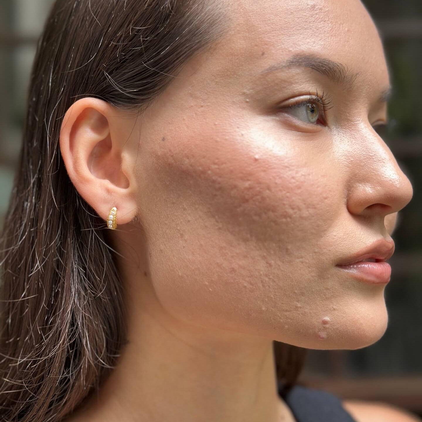 model wears Pearl Antique Gold Huggie Hoop Earrings