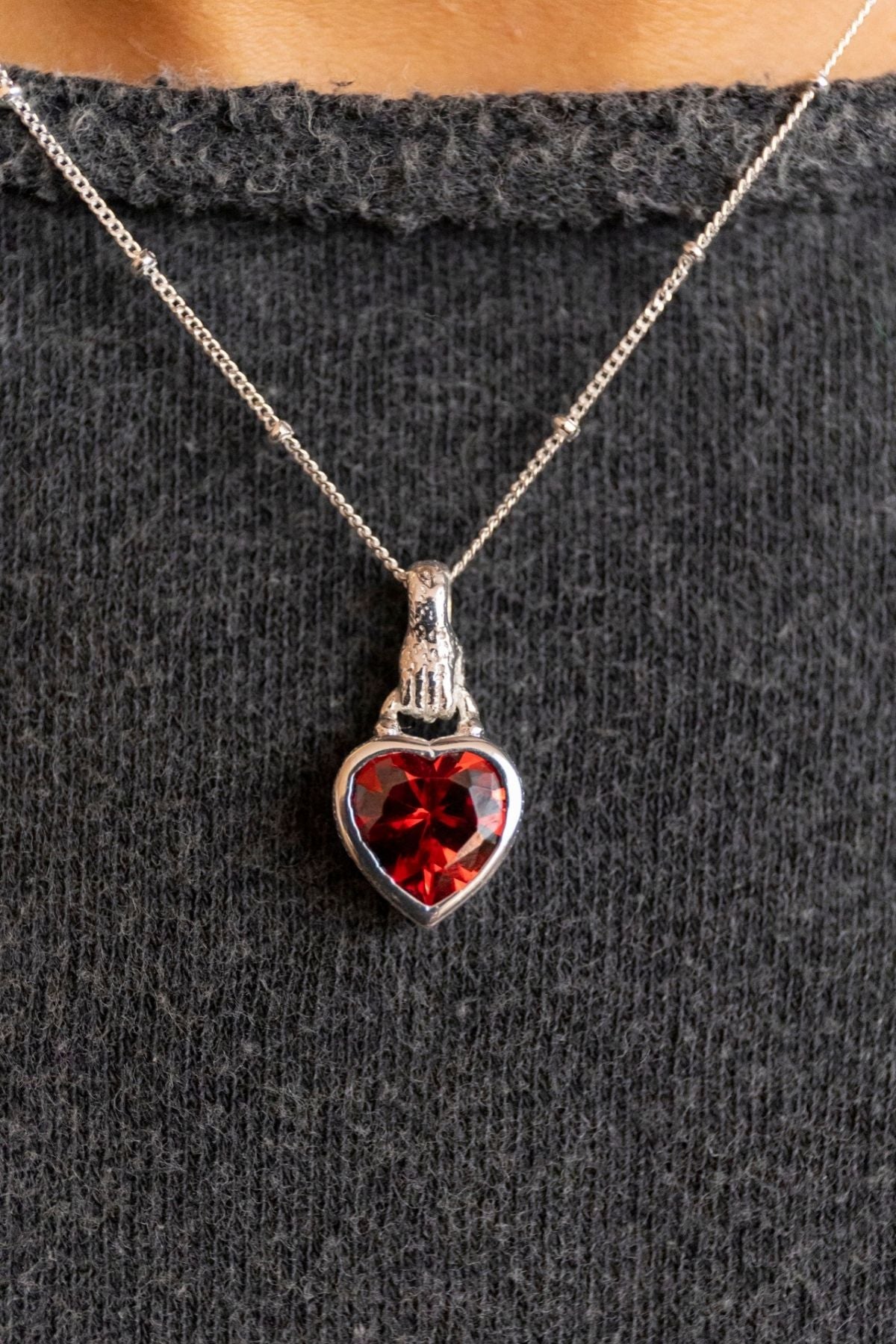 model wears Silver garnet hand in heart necklace on rolo chain