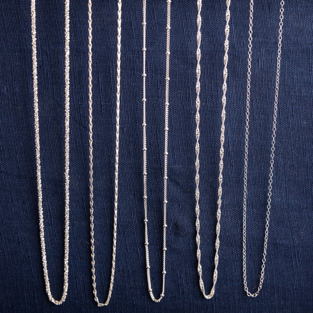 silver chain necklace collection, showing stardust necklace, hayseed necklace, satellite beaded necklace, singapore twisted necklace and simple trace chain necklace