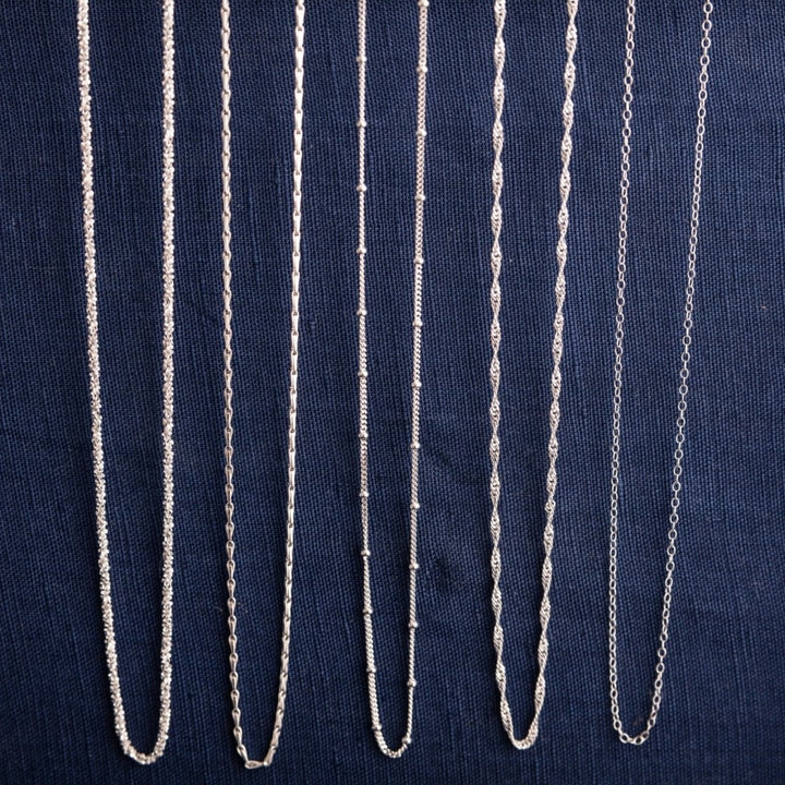 silver chain necklace collection, showing stardust necklace, hayseed necklace, satellite beaded necklace, singapore twisted necklace and simple trace chain necklace