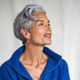Celia wears silver opal birthstone necklace and matching hoop earrings 
