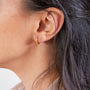 model wears Coral Gold Enamel Huggie Earrings