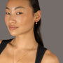 Jade wears Brushed Heart Gold Huggie Hoops
