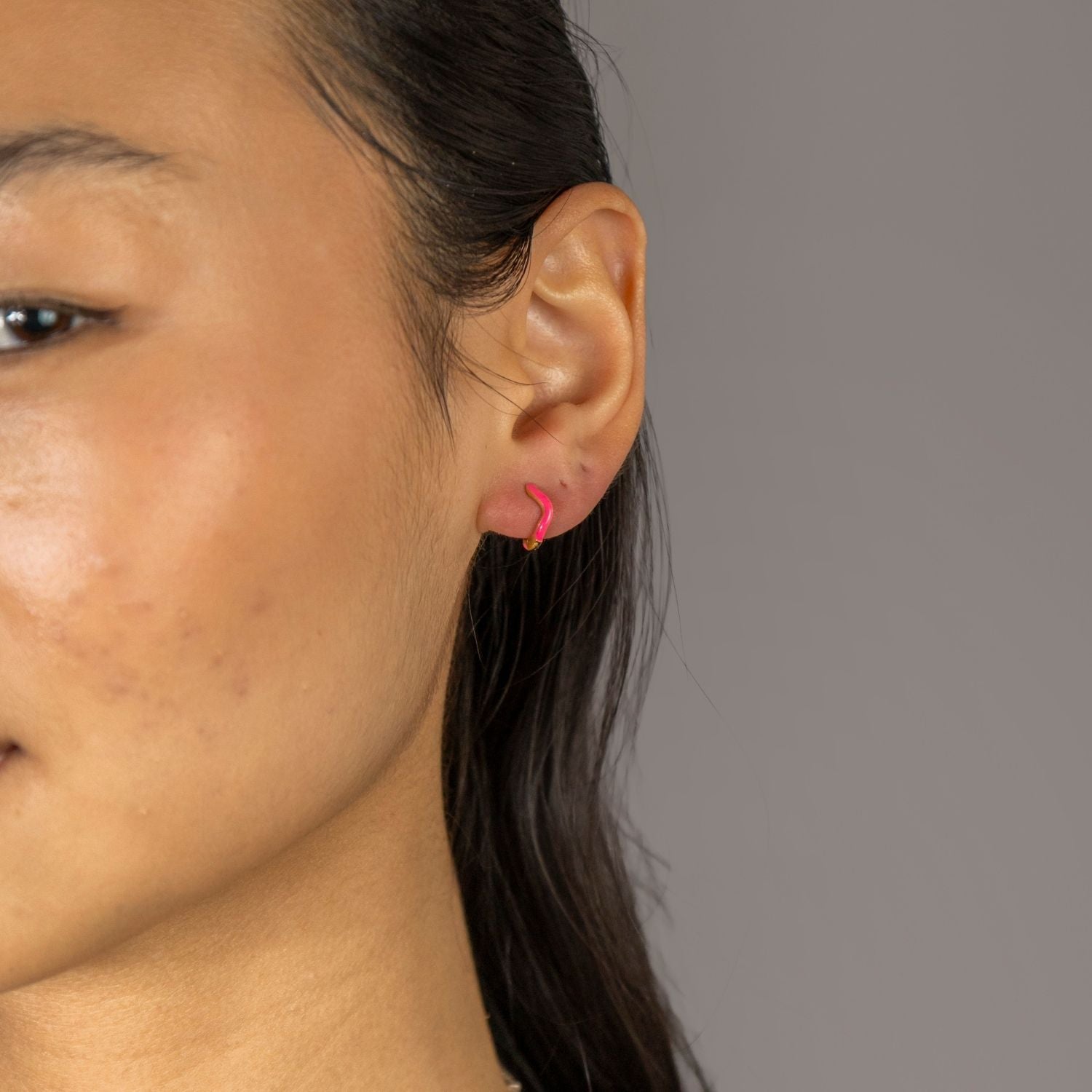 Jade wears Hot Pink Wavy Enamel Huggie Hoops
