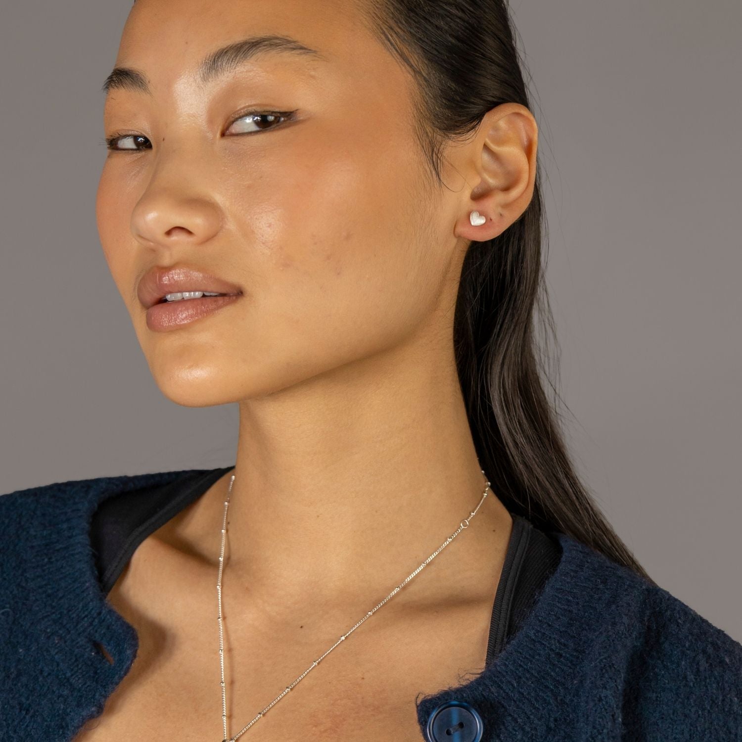 Jade wears Brushed Heart Silver Stud Earrings