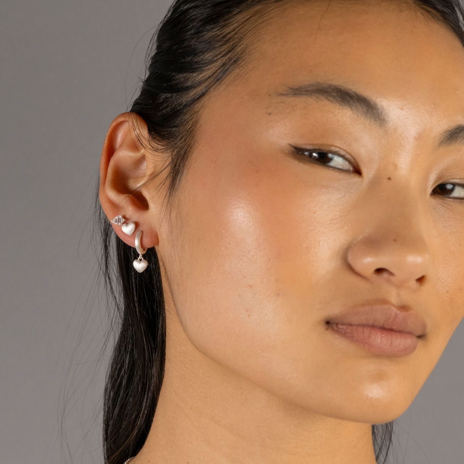 Jade wears Brushed Heart Silver Stud Earrings