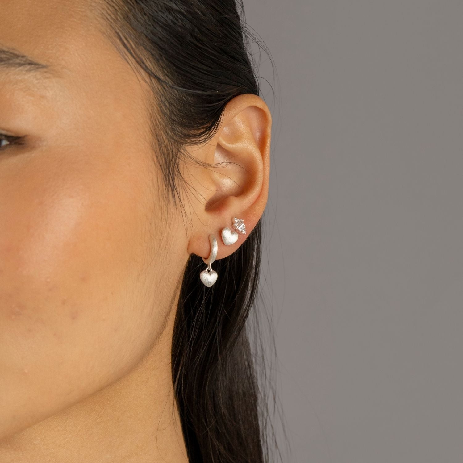 Jade wears Brushed Heart Silver Huggie Hoops