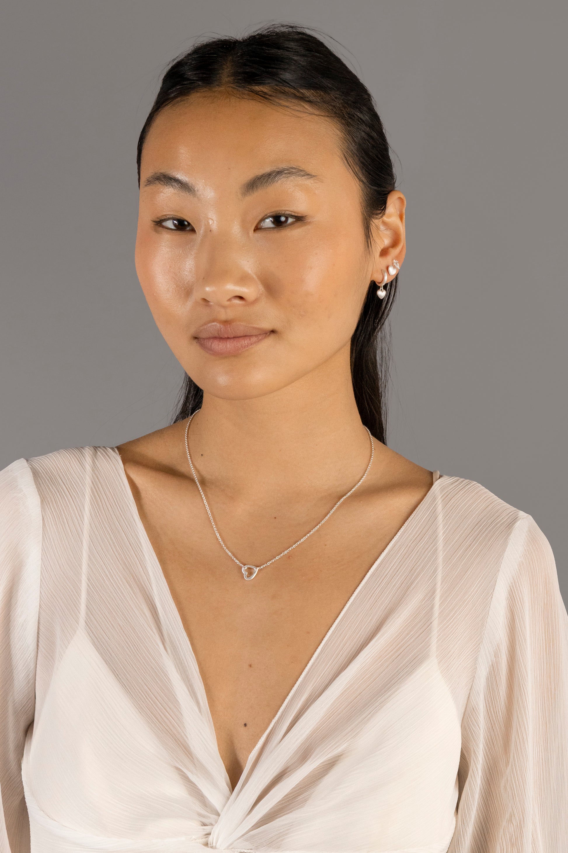 Jade wears Brushed Heart Silver Huggie Hoops