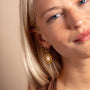 model wears Geometric Mother of Pearl and Gold Statement Hoop Earrings
