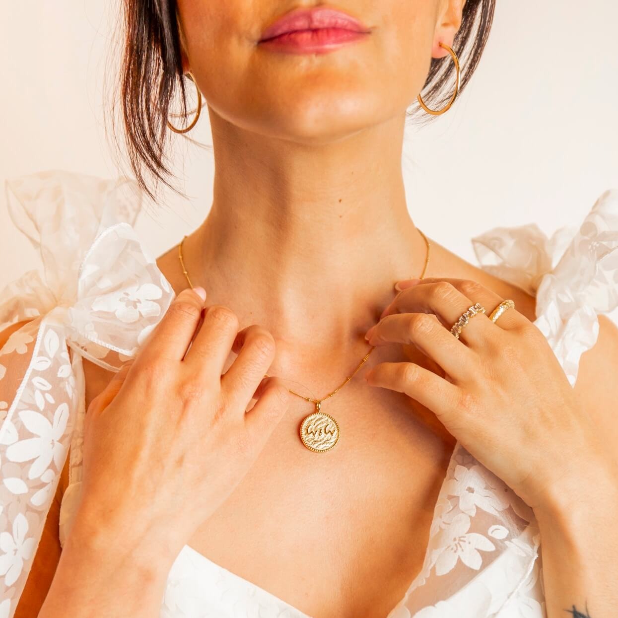 model-wears-14k-gold-vermeil-love-is-love-shorthand-coin-pendant-necklace-and-large-9ct-solid-gold-hoop-earrings-claire-hill-designs