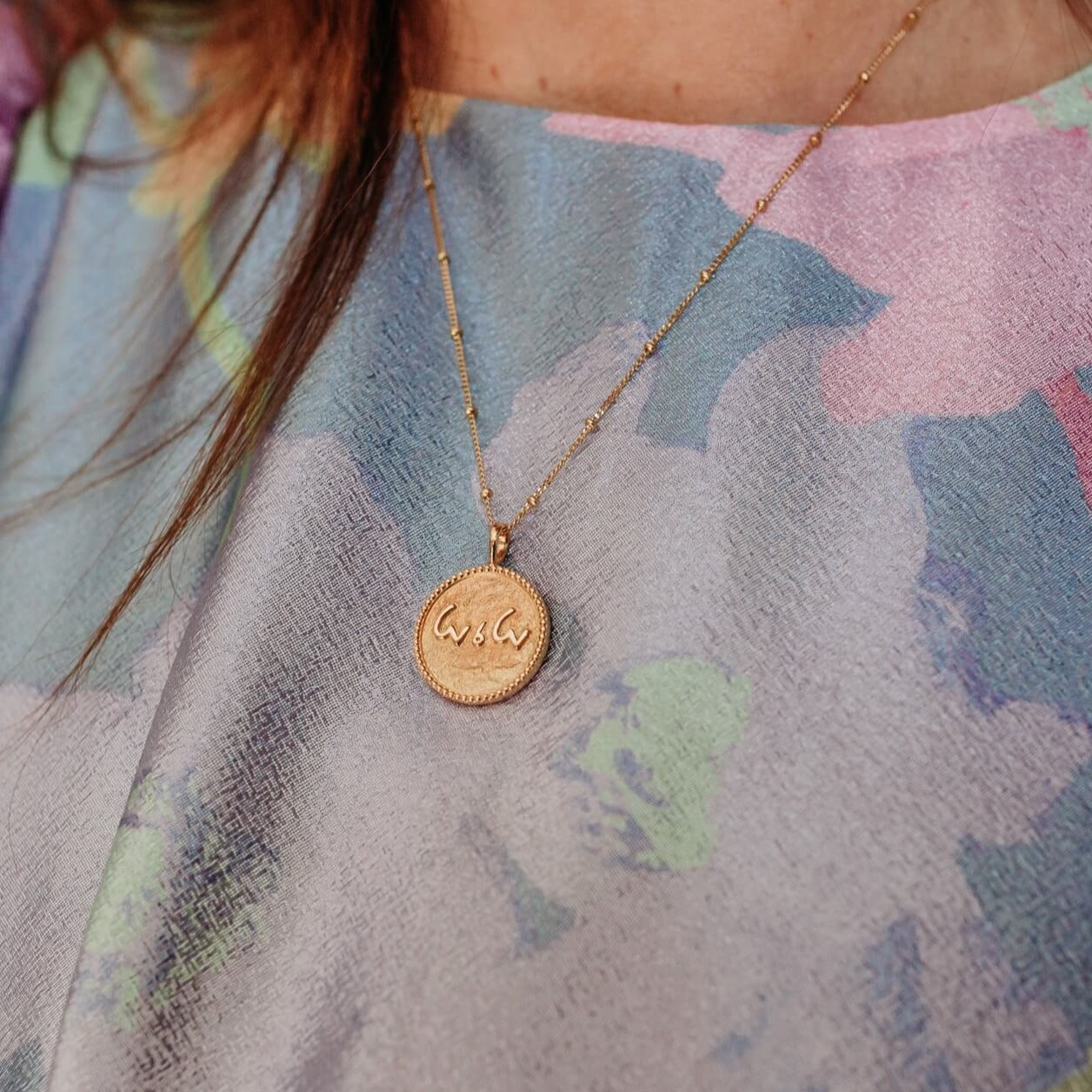 model-wears-14k-gold-vermeil-love-is-love-shorthand-coin-pendant-necklace-claire-hill-designs