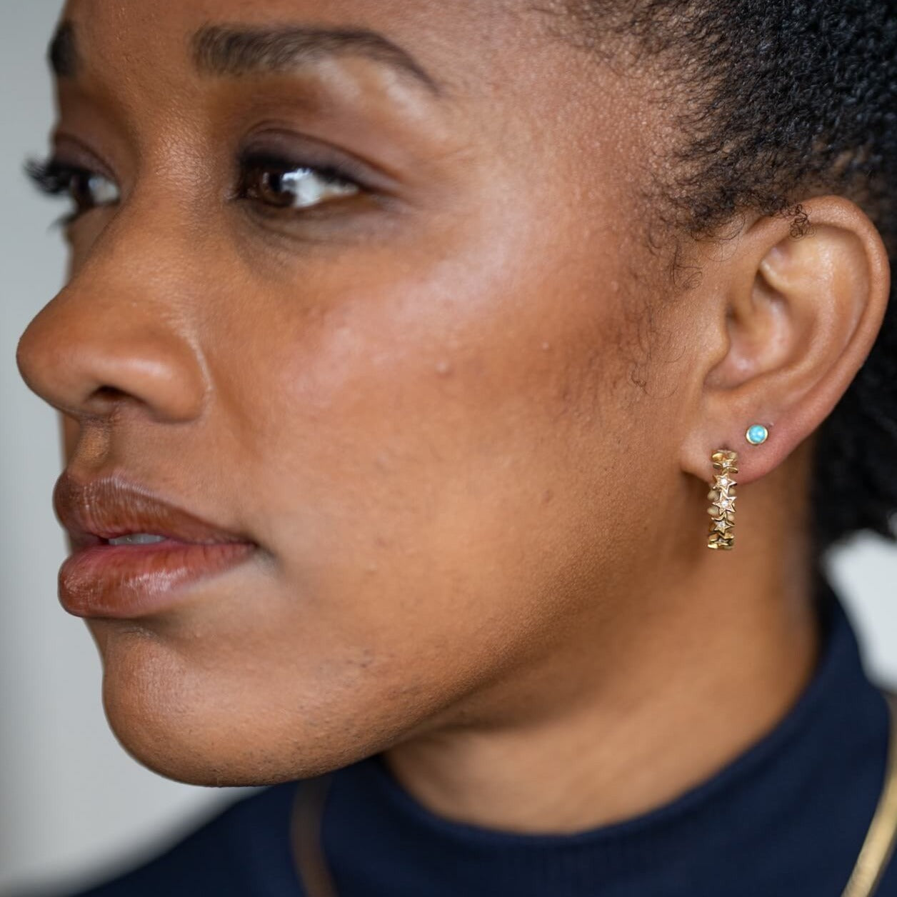 model wears sparkly gold vermeil star hoop earrings and 18k gold vermeil and blue lab-grown opal stud earrings