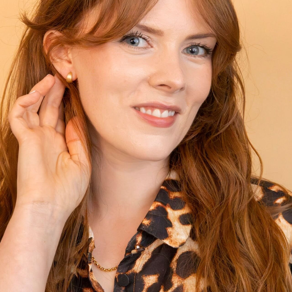 model wears Brushed Gold Chunky Huggie Hoops