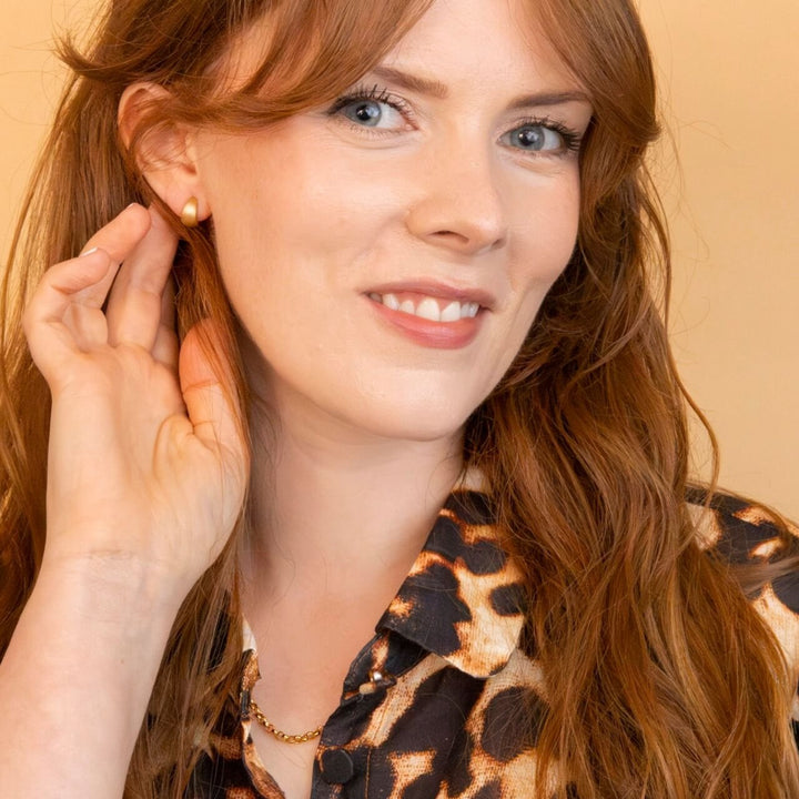 model wears Brushed Gold Chunky Huggie Hoops