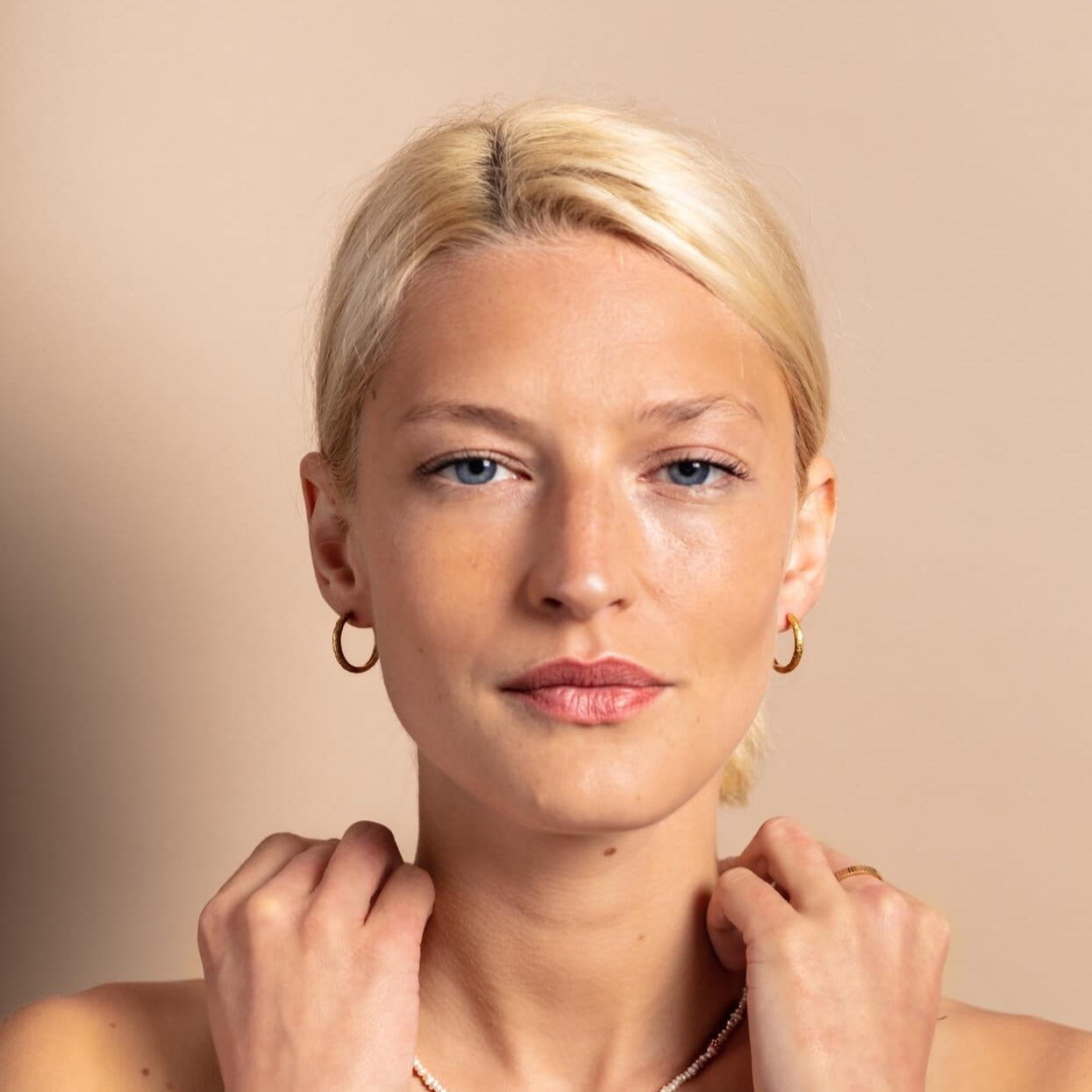model-wears-18k-gold-vermeil-antique-textured-large-hoop-earrings-claire-hill-designs