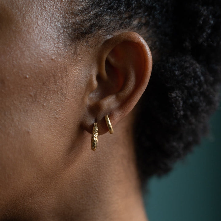  Analyzing image     model-wears-18k-gold-vermeil-diamond-cut-chunky-hoop-earrings-and-18k-gold-vermeil-antique-textured-huggie-hoop-earrings-claire-hill-designs