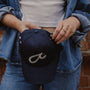 Model holds navy Fuck It Shorthand embroidered baseball cap