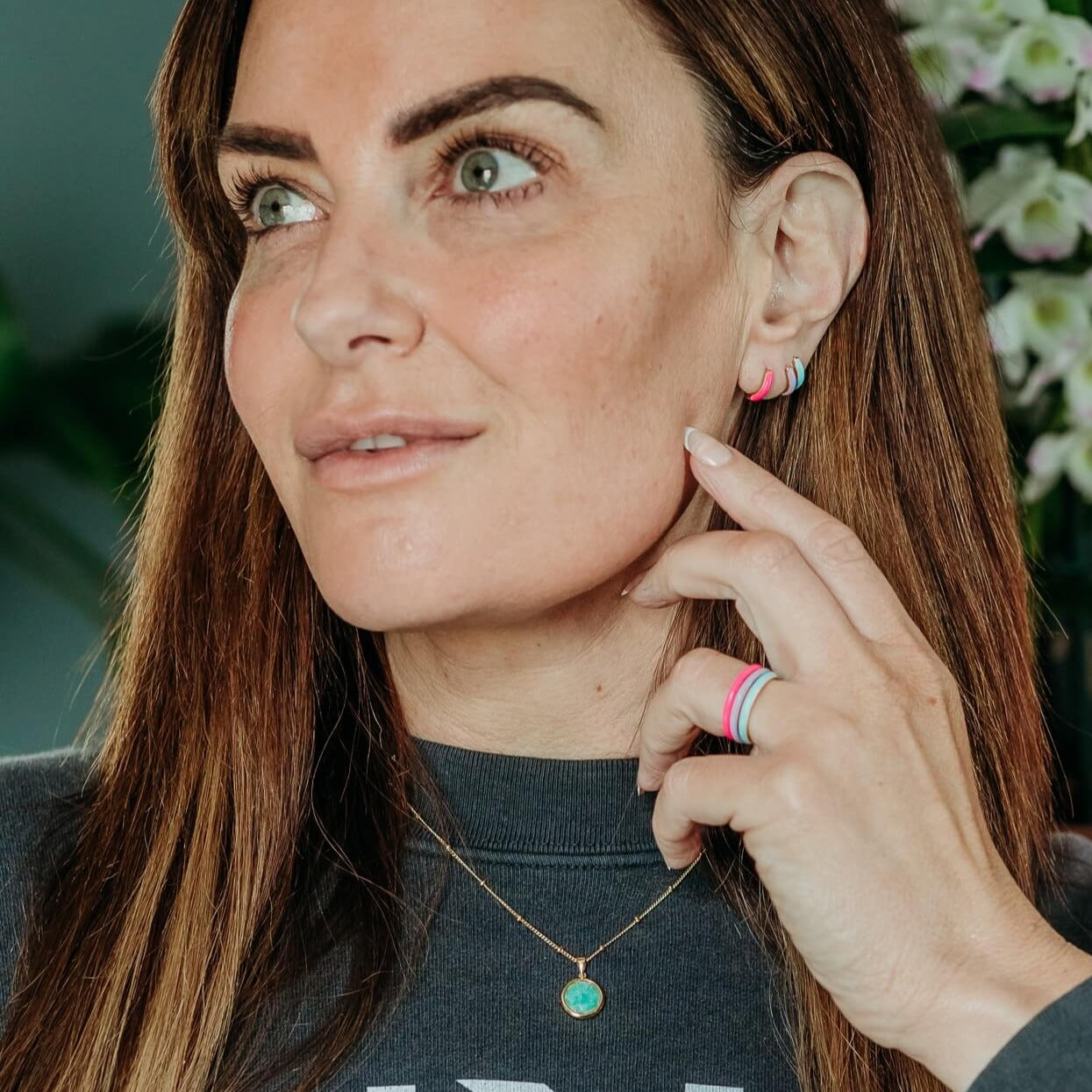 model-wears-amazonite-gold-gemstone-necklace-and-enamel-huggie-hoop-earrings-and-enamel-rings-claire-hill-designs