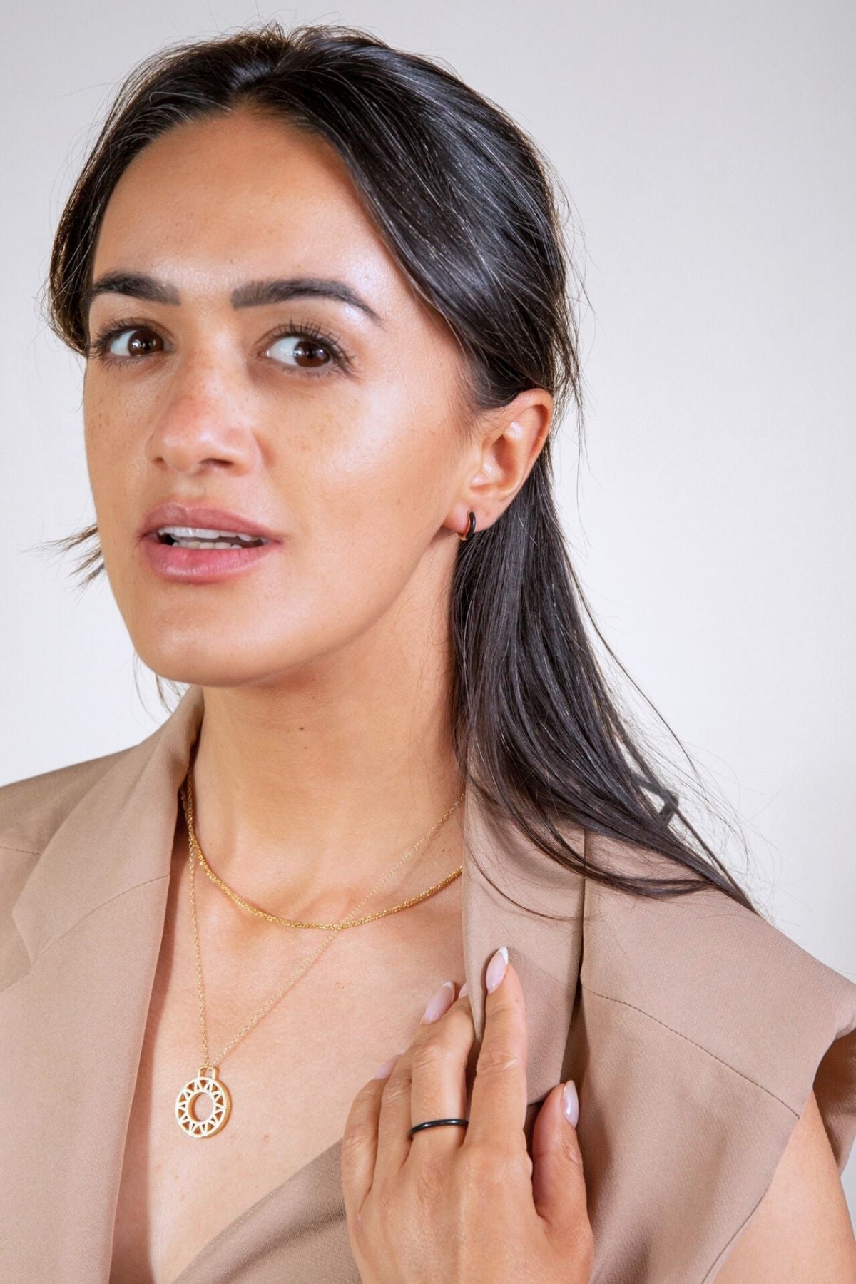   model wears black enamel ring gold geometric necklace and gold stardust necklace