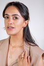 model wears Black Enamel Gold Huggie Hoop Earrings