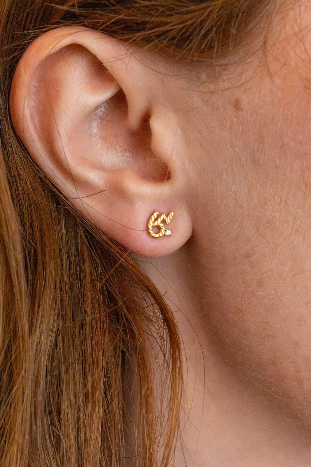 model wears Brave Gold Shorthand Stud Earring