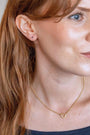 model wear brushed heart connector necklace and sapphire gold labret stud 
