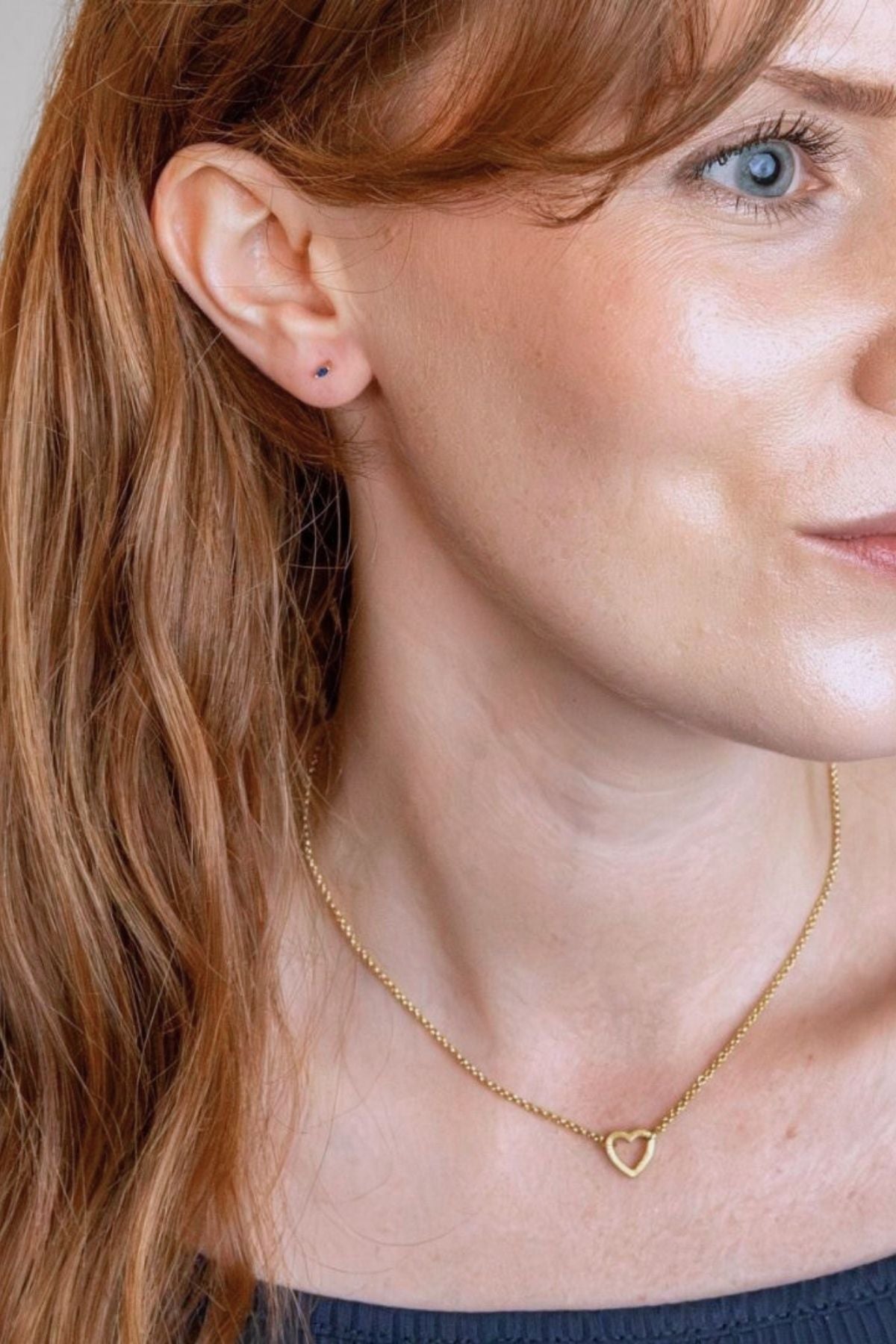 model wear brushed heart connector necklace and sapphire gold labret stud 
