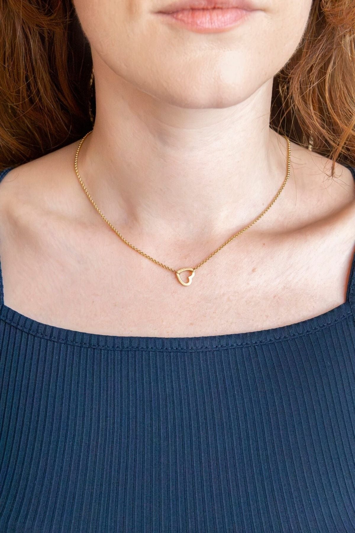 model wears brushed heart connector necklace 
