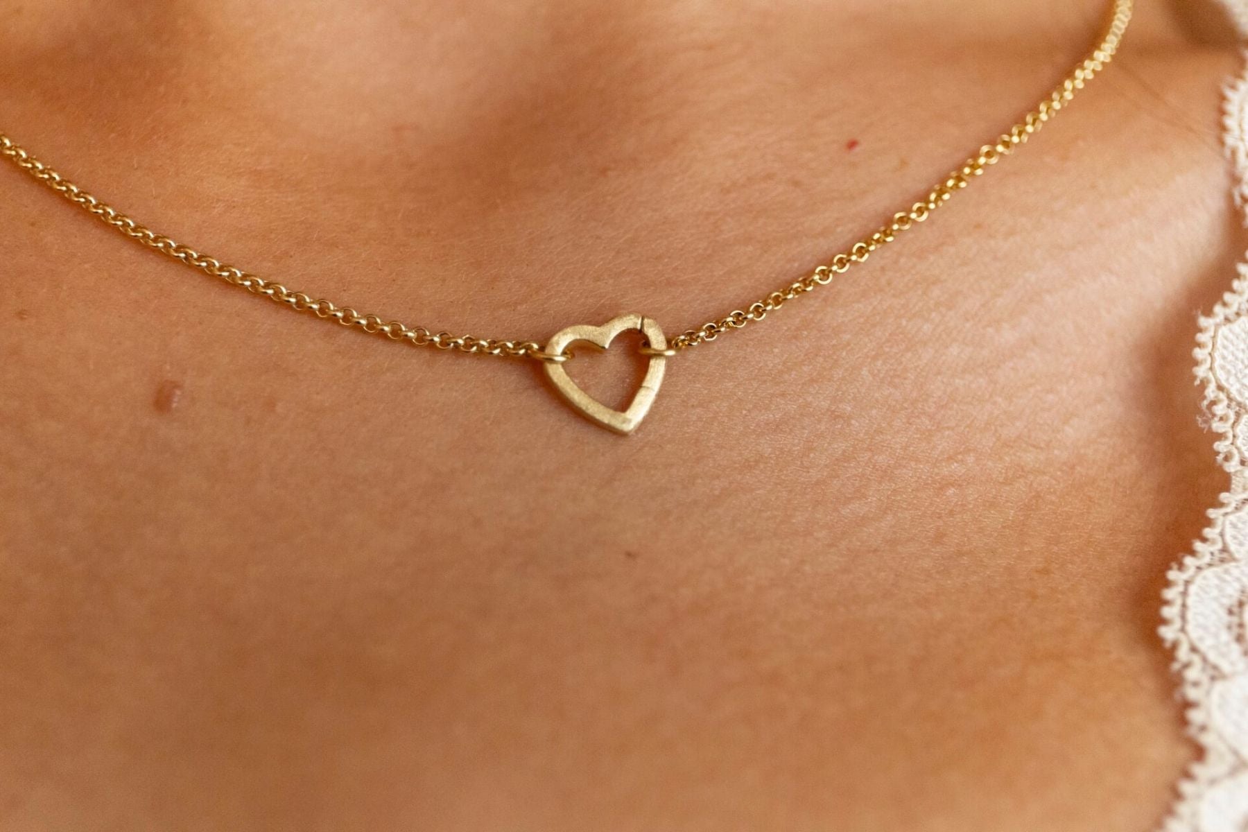 model wears brushed heart connector necklace close up