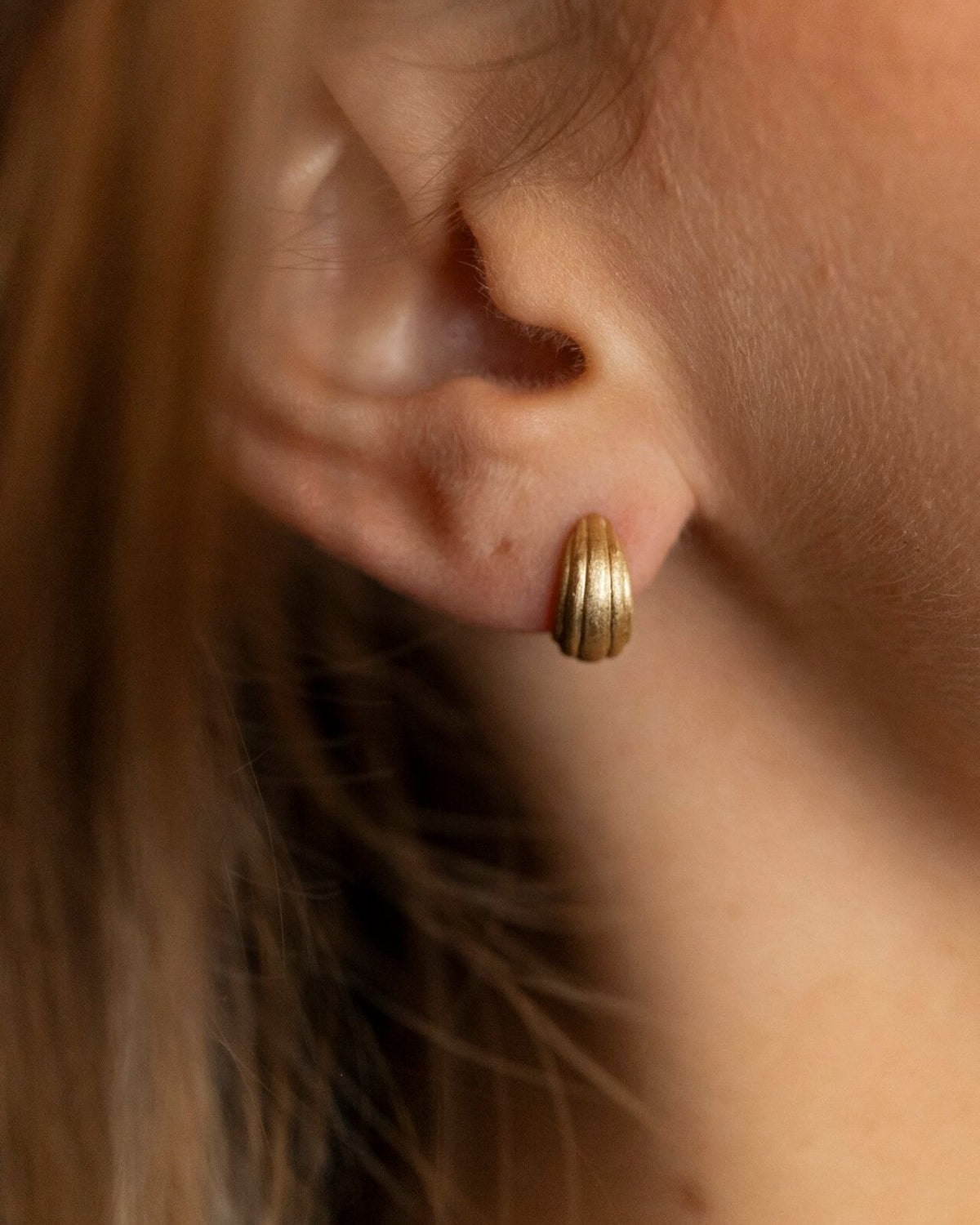 model wears Ridged Chunky Gold Huggie Hoops